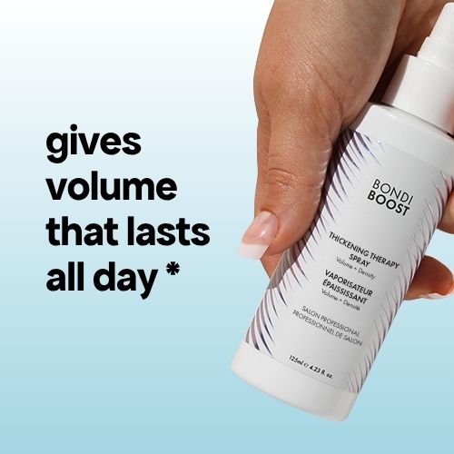 Hand holding a Bondi Boost hair spray can with text about volume lasting all day on a light blue background