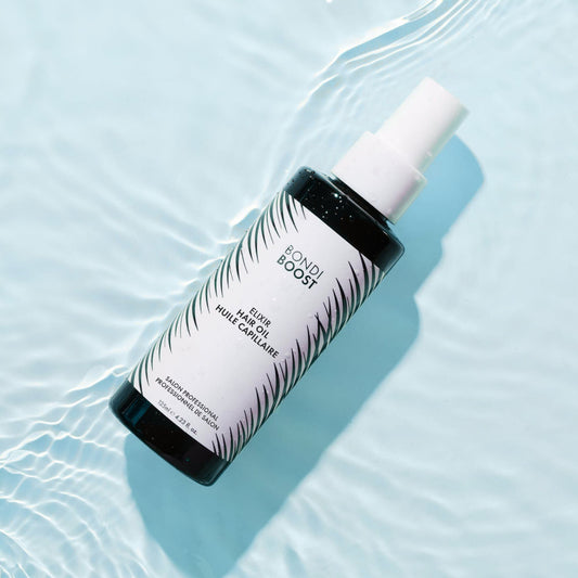 Bottle of Bondi Boost hair oil on water