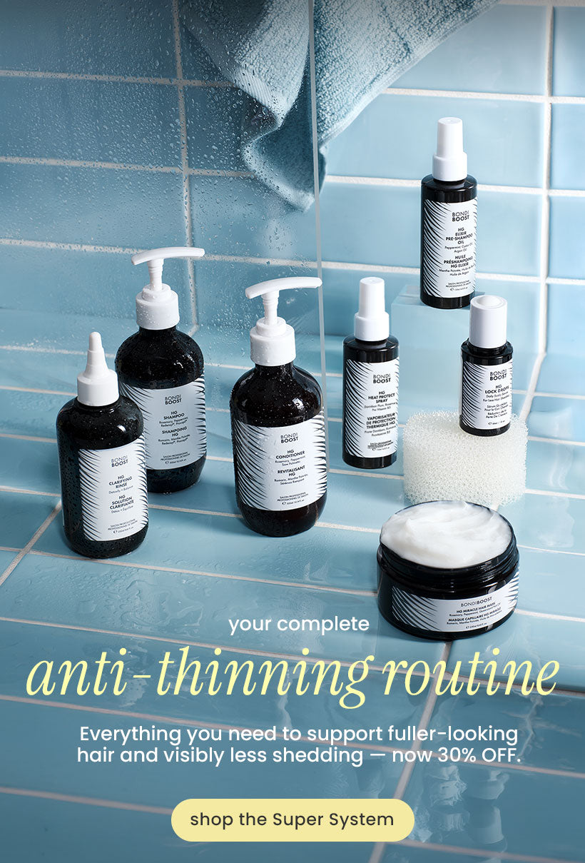 A promotional arrangement of several hair-care bottles and jars with white pump and spray tops, plus a jar of white cream, set against a light blue tiled bathroom-style background with a towel. Large text reads 'anti-thinning routine' with smaller copy below and a 'shop the Super System' callout.