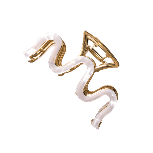 Gold and white snake-shaped hair clip on a black background