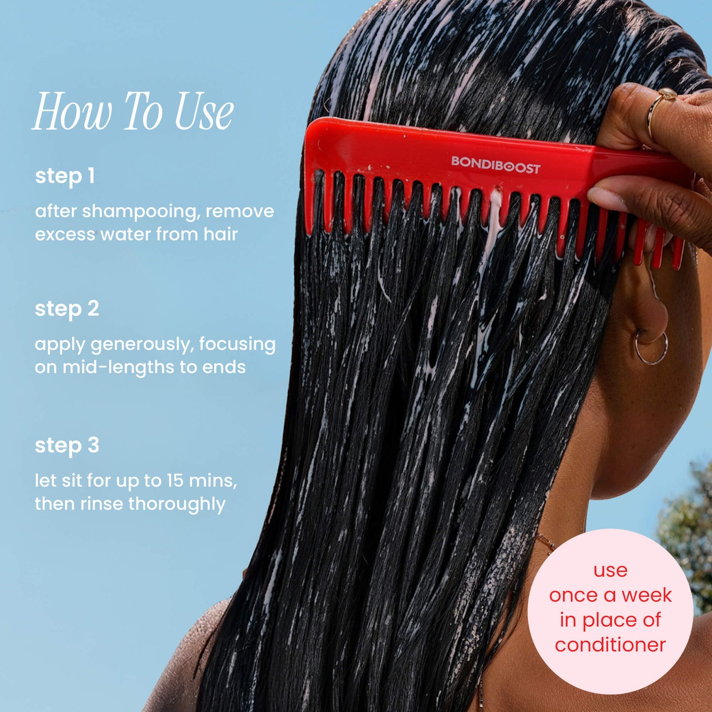Person applying hair product with a red comb against a blue sky background