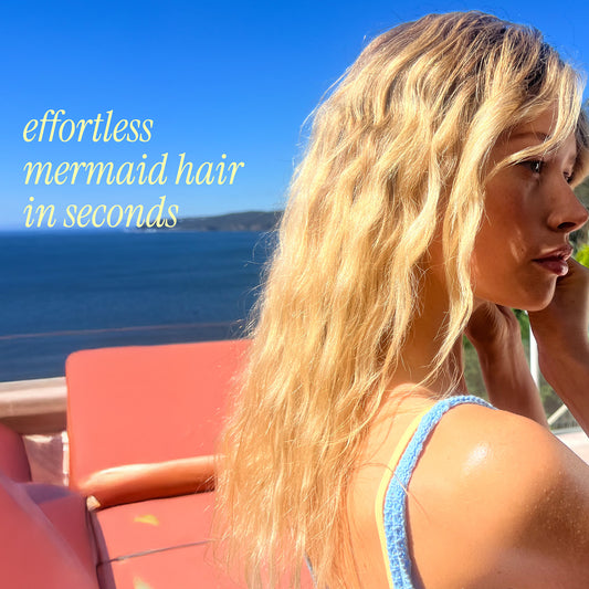 Woman with mermaid-style hair by the ocean with text 'effortless mermaid hair in seconds'.